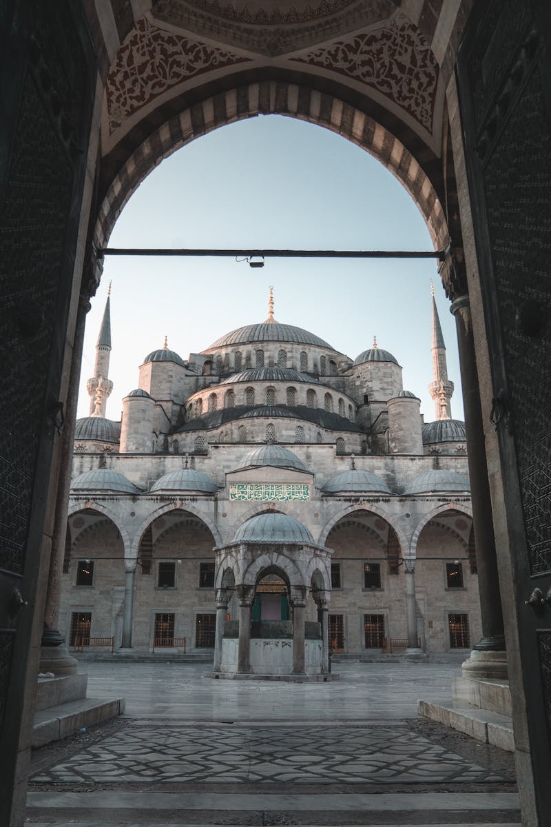 The stunning Blue Mosque in Istanbul, captured through an ornate archway, showcasing its architectural beauty.
